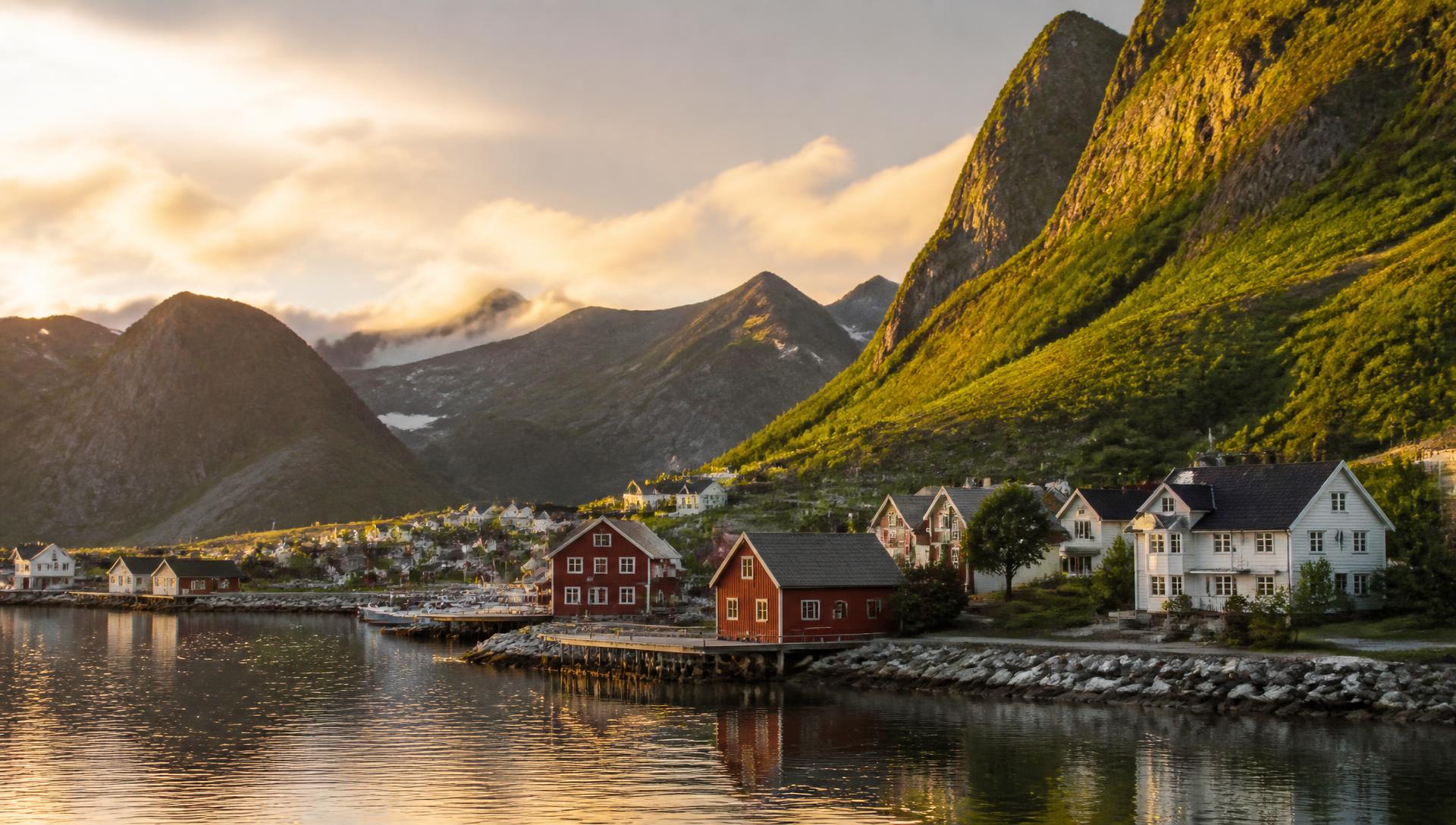Sunrise over a Nordic fjord village of wooden houses beneath green mountains
